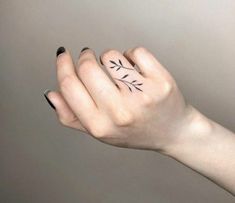 a woman's hand with a small tattoo on it