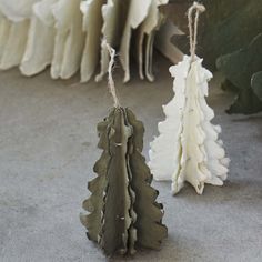 two small ceramic trees are hanging from twine