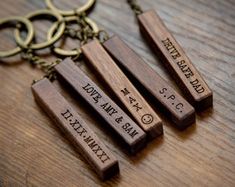 three wooden key chains with engraved names on them