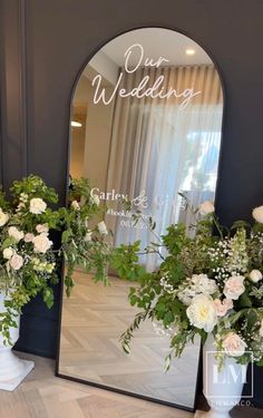 two vases filled with flowers sitting next to a mirror