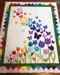 a colorful quilt with butterflies and flowers on it