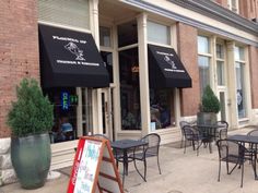 an outside cafe with tables and chairs on the sidewalk