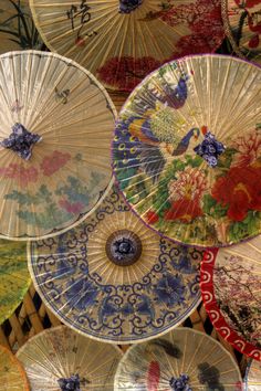 there are many parasols that have been decorated with flowers and birds on them