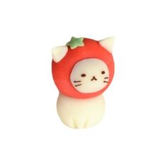 a close up of a cat figurine with a strawberry on it's head