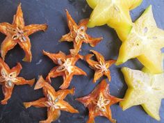 several pieces of fruit are arranged on a slate surface with star shaped orange peels