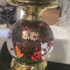 a glass vase filled with lots of different types of flowers and leaves on top of a table