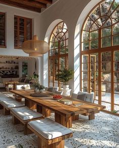 a large dining room with lots of windows and wooden furniture in it's center