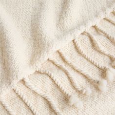 a white blanket with tassels on it