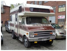 an rv is parked in front of some cars