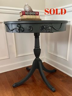 a black table with books on top and sold sign in the background for $ 10