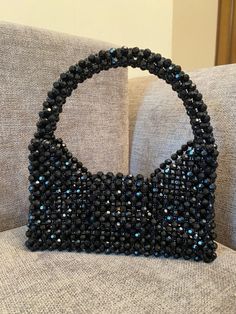 black beaded purse sitting on top of a couch