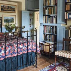 a bedroom with a bed, bookshelf and chair