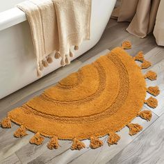 a bath tub sitting next to a rug with tassels