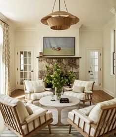 a living room filled with furniture and a painting on the wall above it's fireplace