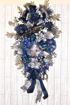 a blue and silver christmas wreath hanging on a wall