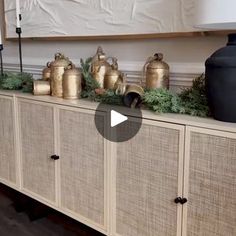 an image of a living room setting with vases and plants on the sideboard