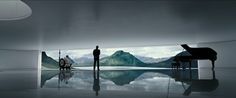 two people standing in front of a piano with mountains in the background and water reflecting on the floor