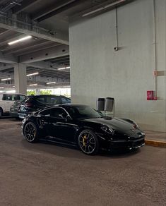 two black sports cars parked next to each other in a parking garage