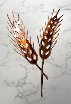 a close up of a metal plant on a marble counter top with white and gray background