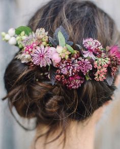 a close up of a woman wearing a flower headpiece with flowers in her hair