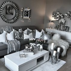 a living room filled with lots of furniture and mirrors on the wall above it's coffee table