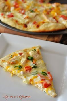 a slice of pizza sitting on top of a white plate next to a skillet