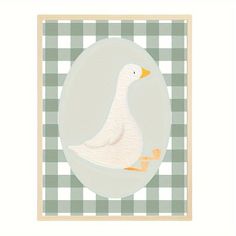 a white duck sitting on top of a green and white checkered table cloth with a wooden frame