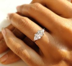 a woman's hand with a diamond ring on it