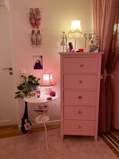 a pink dresser sitting next to a window in a bedroom