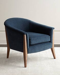 a blue chair sitting on top of a carpeted floor next to a white wall