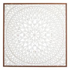 a white wall hanging with an intricate design