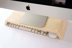 an apple computer sitting on top of a white desk next to a keyboard and mouse