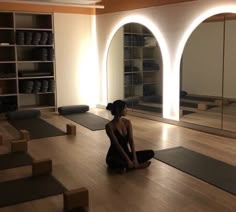 a woman sitting on the floor in a yoga studio