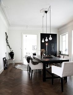 a black and white dining room with wood flooring