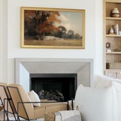 a living room filled with furniture and a painting on the wall over a fire place