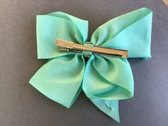 a green bow with two metal clips on it's side, sitting on top of a table