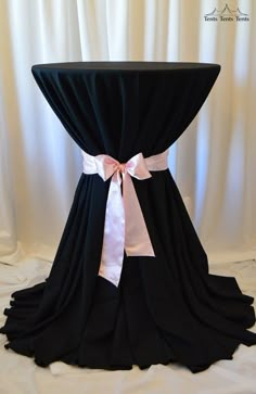 a black table topped with a white ribbon and bow on it's back cover