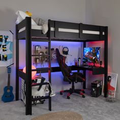 a loft bed with a desk underneath it and a computer on the top shelf in front of it