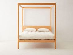 a bed with white pillows and a wooden frame