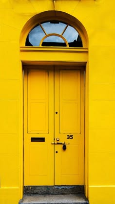 a yellow building with two doors and windows