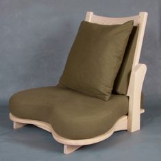 a chair that is made out of wood and has two pillows on top of it