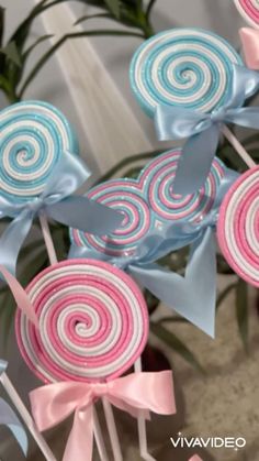 several lollipops with bows on them are sitting next to some potted plants