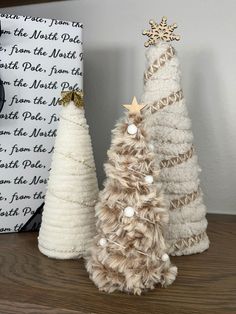 two small christmas trees sitting on top of a wooden table