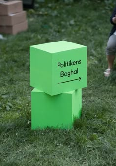 a person kneeling down next to a green block