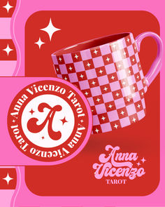 a pink and red coffee mug sitting on top of a table next to a sticker