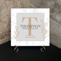 a marble and gold wedding guest sign with the letter t on it