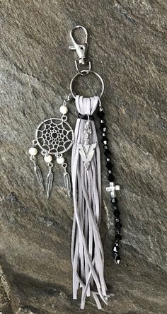 a tasseled keychain on a rock with beads and charms hanging from it