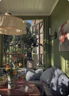 the sun shines in through an open window into a room with green walls and furniture