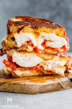 two grilled cheese sandwiches stacked on top of each other with tomatoes and mozzarella