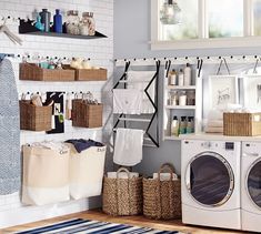 a washer and dryer in a room with baskets on the wall next to it